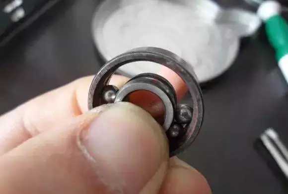 用手将轴承拿起，需要注意要向有滚珠的方向顶住
